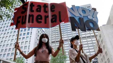 People hold up signs during a protest against Japan's state funeral for former Prime Minister Shinzo Abe in Tokyo on September 27.