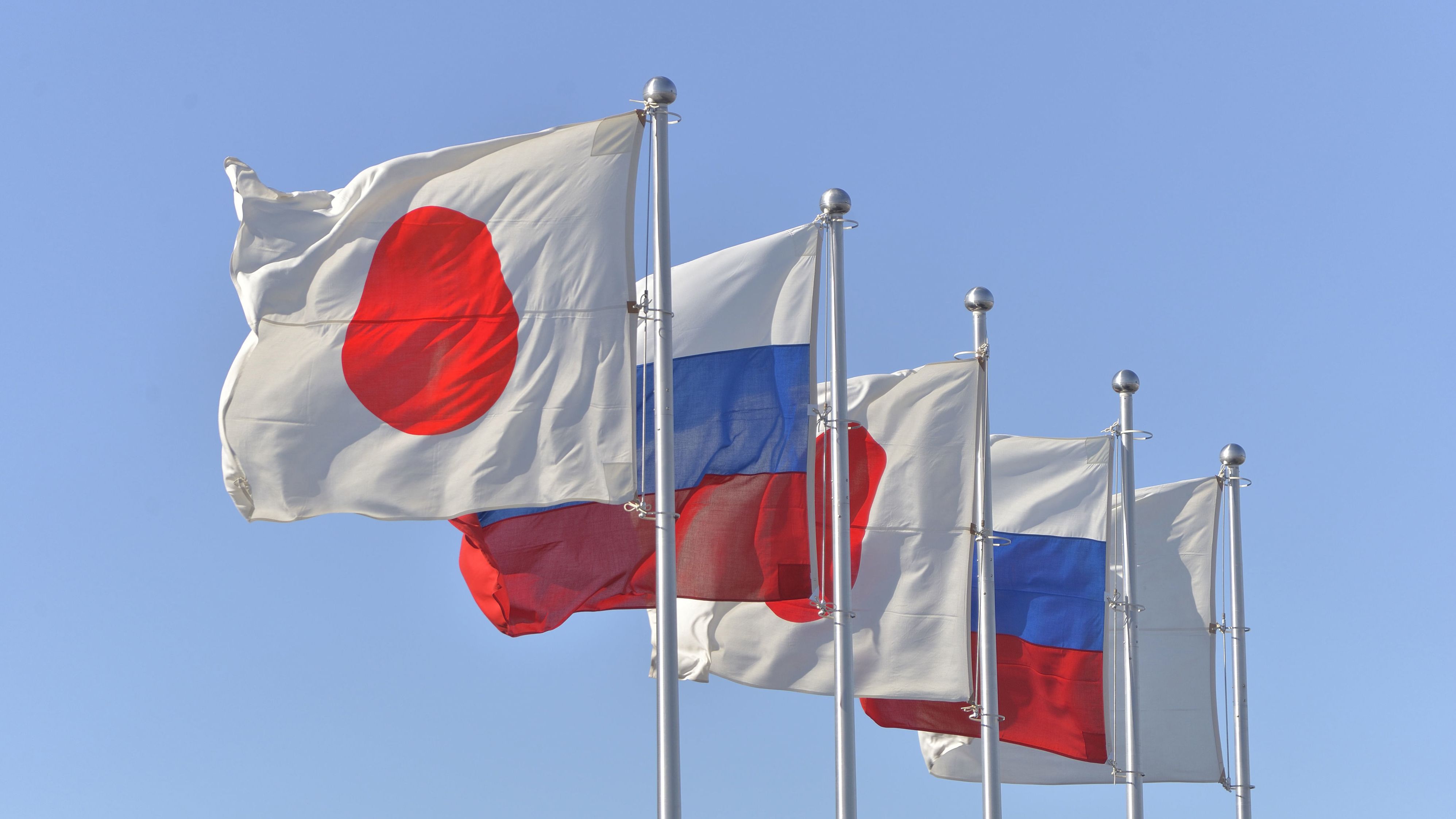 Japanese and Russian national flags flutters in the wind at the Haneda Airport in Tokyo, Japan.