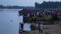 People gather along the banks of the Karatoya river after a boat capsized near the town of Boda on September 25, 2022, 