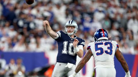 Cooper Rush throws a pass against Oshane Ximines of the New York Giants during the fourth quarter in the game.