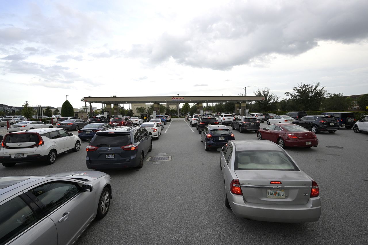 People wait in lines to fuel their vehicles at a Costco store in Orlando on Monday.