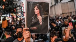 A protester holds a portrait of Mahsa Amini during a protest against her killing. (OZAN KOSE/AFP via Getty Images)