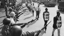 National Guard troops line Beale Street, in Memphis, Tennessee, as protesters wearing placards reading "I Am a Man" pass by, March 29, 1968.