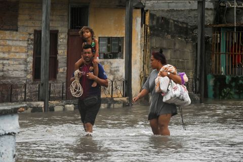 People walk through a flooded street in Batabano, Cuba, on Tuesday.