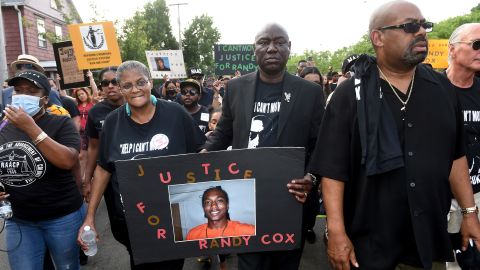 Doreen Coleman, left, mother of Richard 'Randy' Cox, Jr., walks next to civil rights attorney Benjamin Crump during a march for Justice for Randy Cox on July 8.