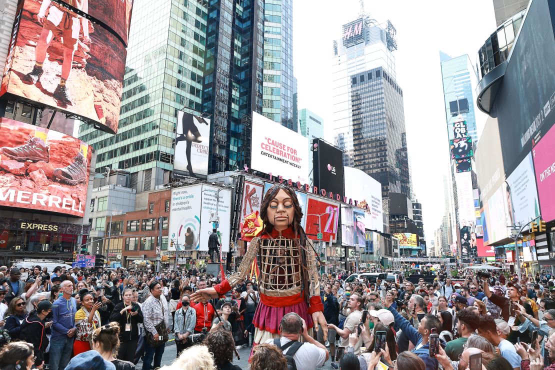 The 12-foot puppet known as Little Amal walks through Times Square as onlookers watch on September 16, 2022.