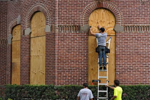 Workers board up the windows on the University of Tampa campus ahead of Hurricane Ian on Tuesday, September 27.
