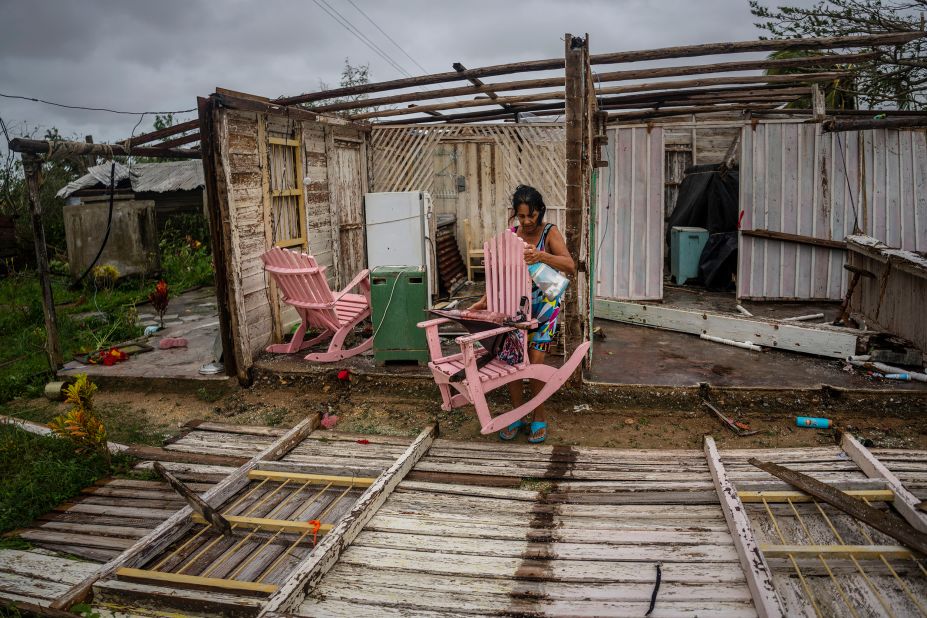 Maria Llonch retrieves belongings from her home in Pinar del Rio, Cuba, on Tuesday.