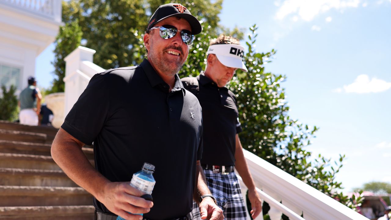 Mickelson and Poulter walk to the course during day two of the LIV Golf Invitational at Bedminster.