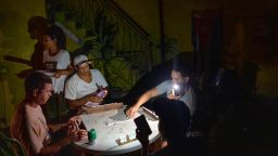 People play dominoes by flashlight during a blackout in Havana, Cuba, Wednesday, Sept. 28, 2022. Cuba remained in the dark early Wednesday after Hurricane Ian knocked out its power grid and devastated some of the country's most important tobacco farms when it hit the island's western tip as a major storm. (AP Photo/Ramon Espinosa)
