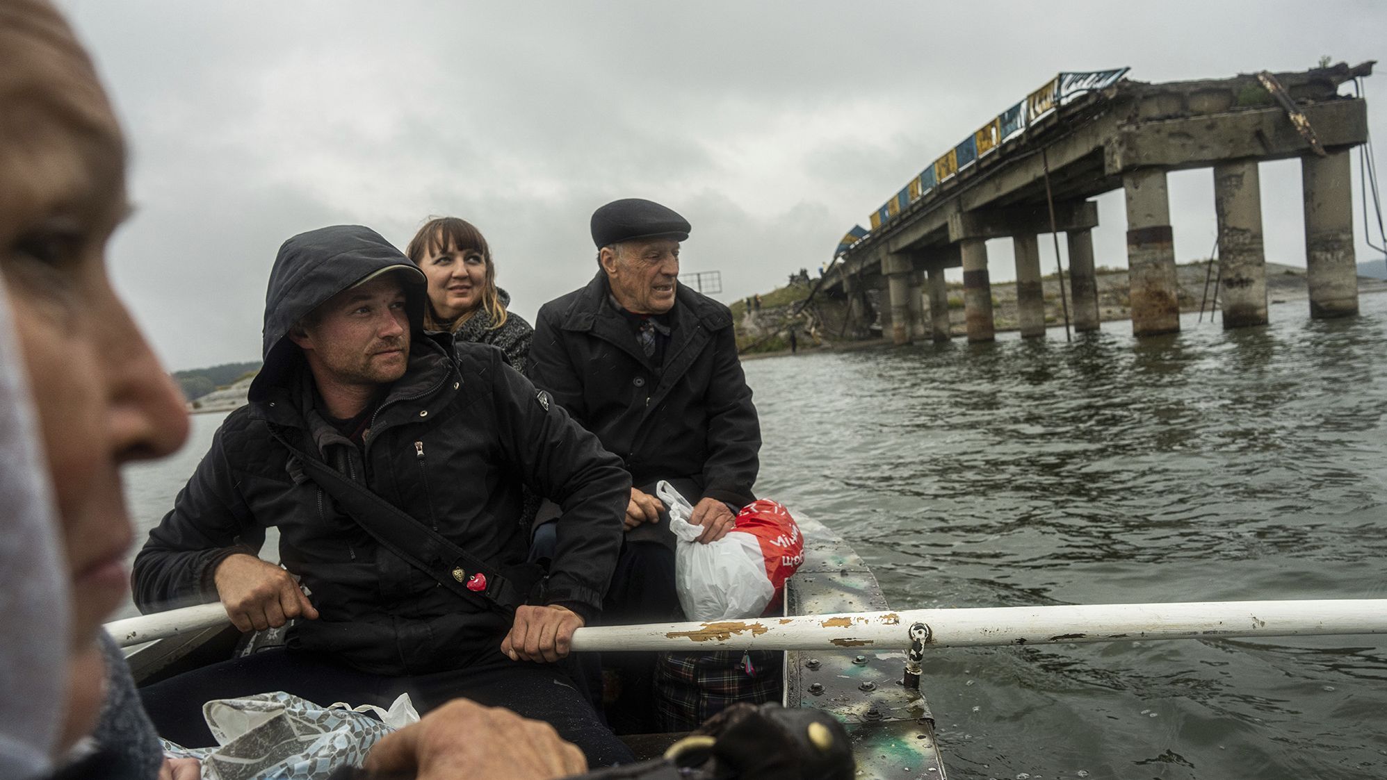 Anton Krasyvyi rows passengers across the Siverskyi-Donets river in front of a destroyed bridge, so they can visit relatives in Staryi-Saltiv, Ukraine, on September 27.