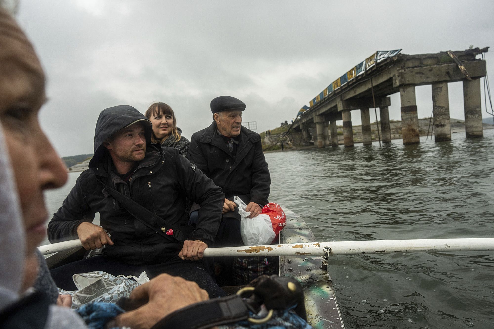 Anton Krasyvyi rows passengers across the Siverskyi-Donets river in front of a destroyed bridge, so they can visit relatives in Staryi-Saltiv, Ukraine, on September 27.