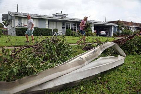 Gary and Sharon Adams clear their yard of debris in Hollywood, Florida, on Wednesday, September 28.