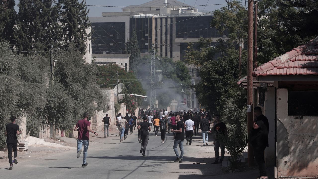Palestinians run during clashes with Israeli forces in the city of Jenin on September 28, 2022. 