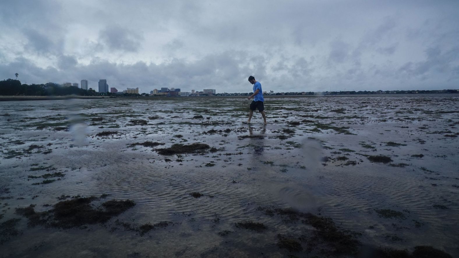 A man walks where <a href="https://www.cnn.com/us/live-news/hurricane-ian-florida-updates-09-28-22/h_a3f82ffac9c07dccfd47dec0e86df9c5" target="_blank">water was receding</a> from Tampa Bay on Wednesday.