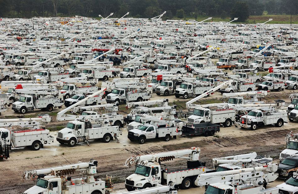 Utility trucks are staged in a rural lot Wednesday in The Villages, a Florida retirement community.