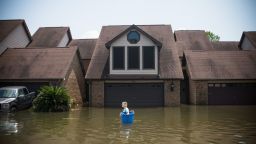 TOPSHOT - Jenna Fountain carries a bucket down Regency Drive to try to recover items from their flooded home in Port Arthur, Texas, September 1, 2017.
Storm-weary residents of Houston and other Texas cities began returning home to assess flood damage from Hurricane Harvey but officials warned the danger was far from over in parts of the battered state. / AFP PHOTO / Emily Kask        (Photo credit should read EMILY KASK/AFP via Getty Images)