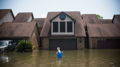 Jenna Fountain carries a bucket to recover items after Hurricane Harvey in 2017 in Port Arthur, Texas.