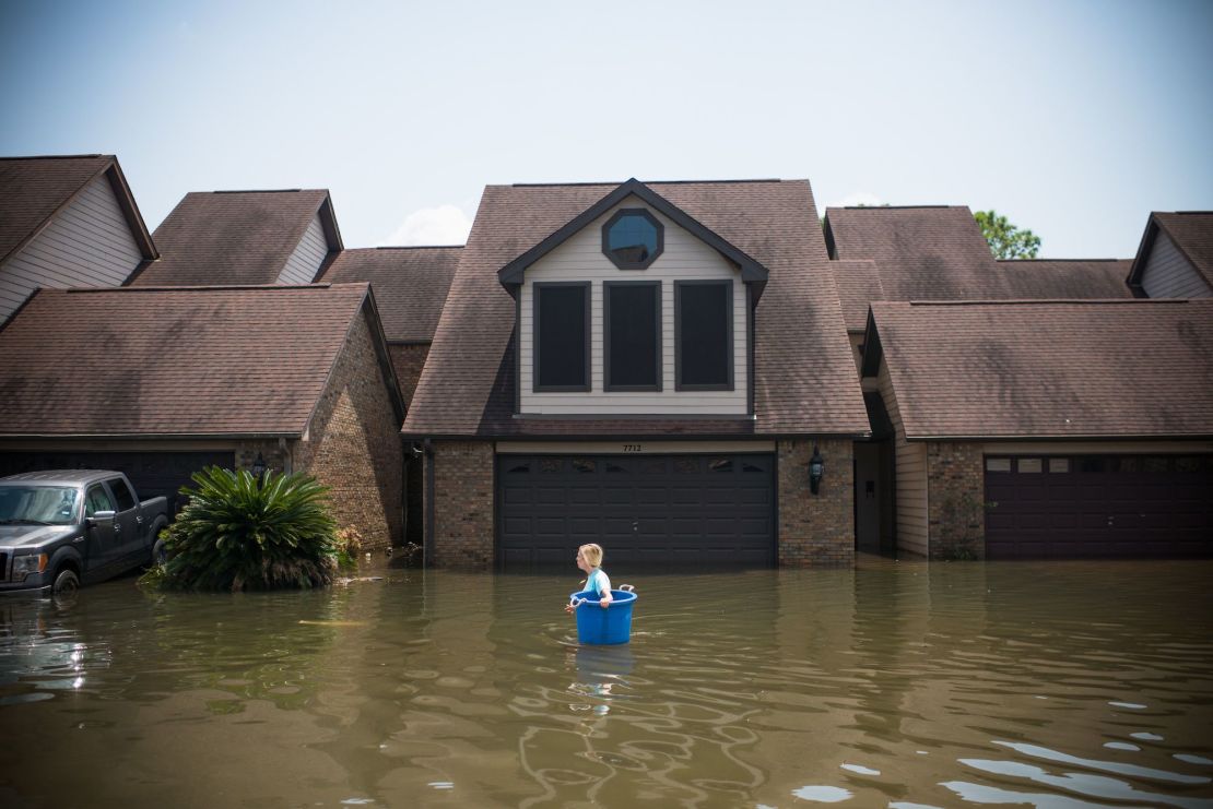 Jenna Fountain carries a bucket to recover items in Port Arthur, Texas, after Hurricane Harvey in 2017.