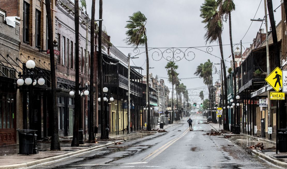 A man stands in the middle 7th Street in Ybor City on the rain soaked streets, a few hours before the high winds from Hurricane Ian hit Tampa.