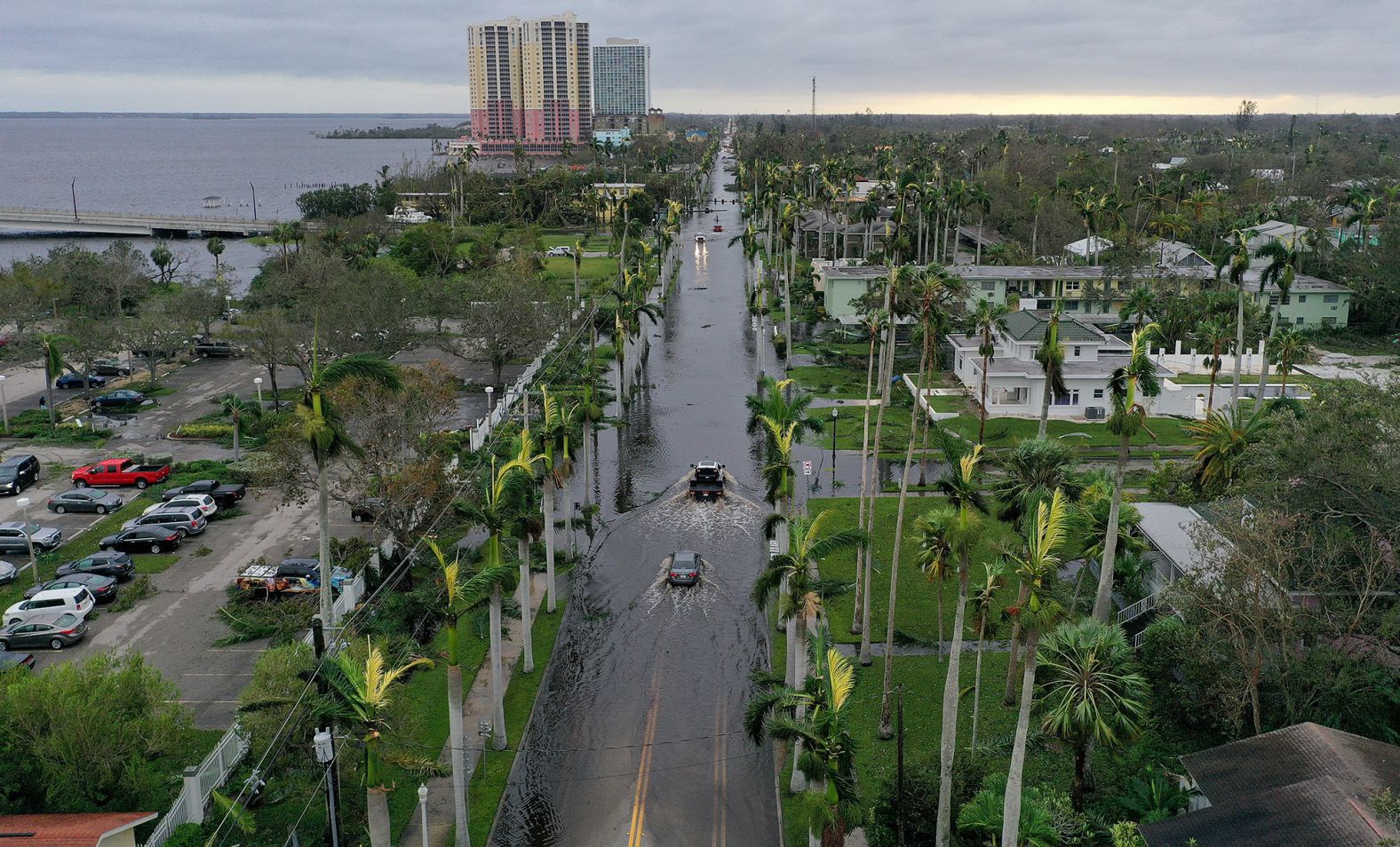 Vehicles make their way through flooded streets in Fort Myers on Thursday.