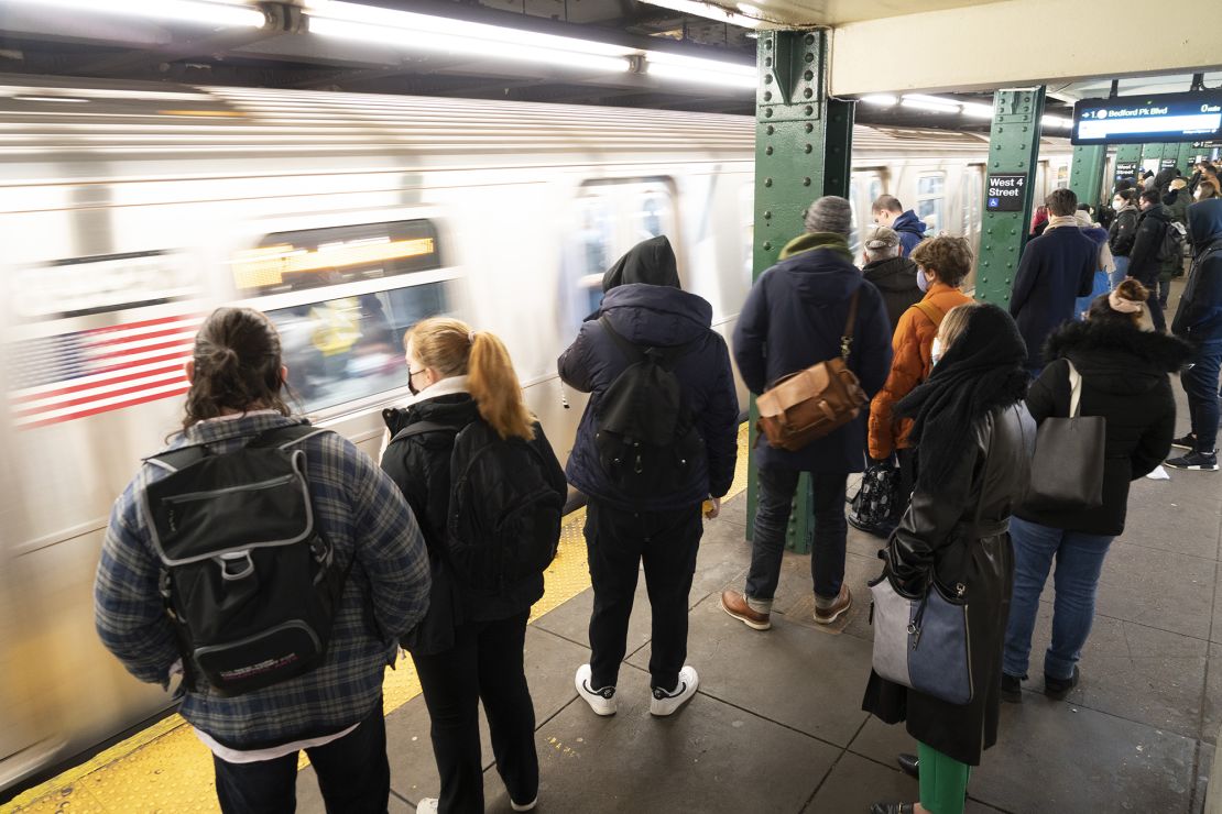 Commuters wait on the platform to board a subway at a station in New York on Monday, March 28, 2022. 