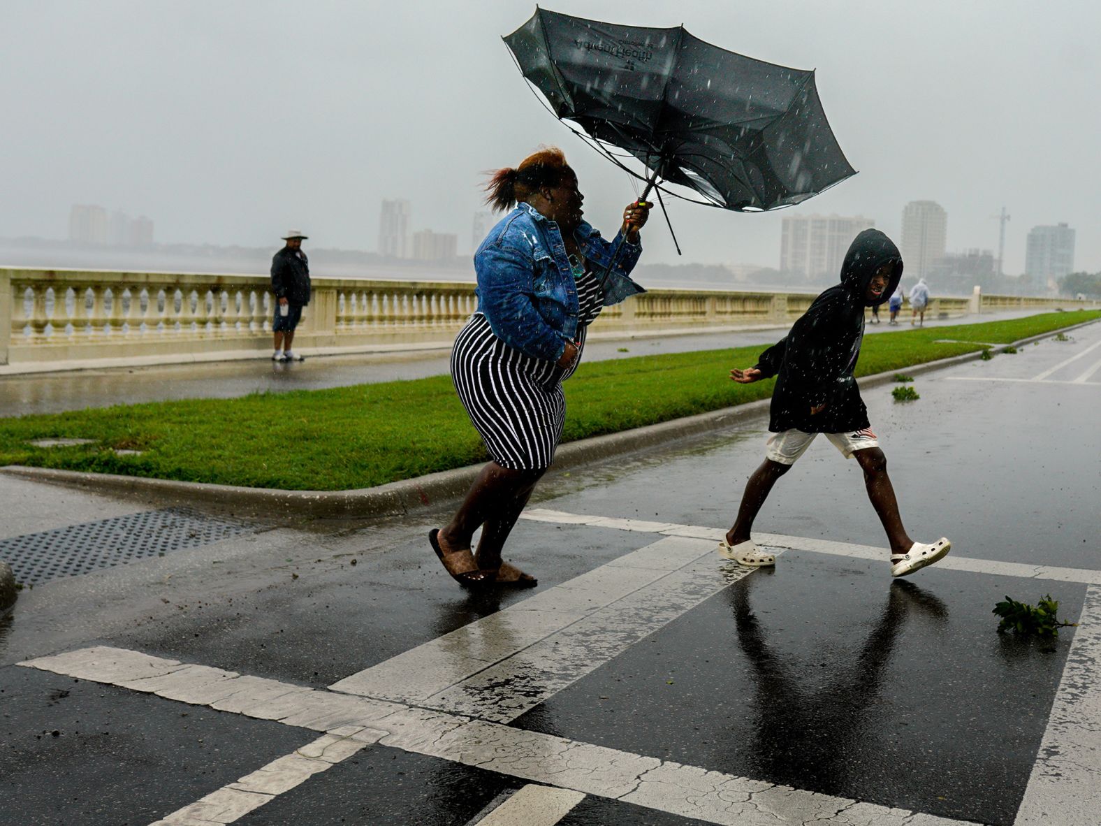 A woman holds an umbrella inverted by the wind in Tampa on Wednesday.