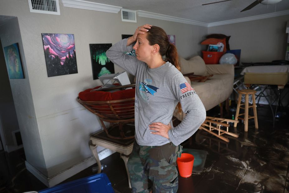 Stefanie Karas stands in her flooded apartment in Fort Myers on Thursday. She is an artist and was salvaging what she could from her home.