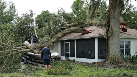 People survey damage to their home in Valrico, Florida, on Thursday.