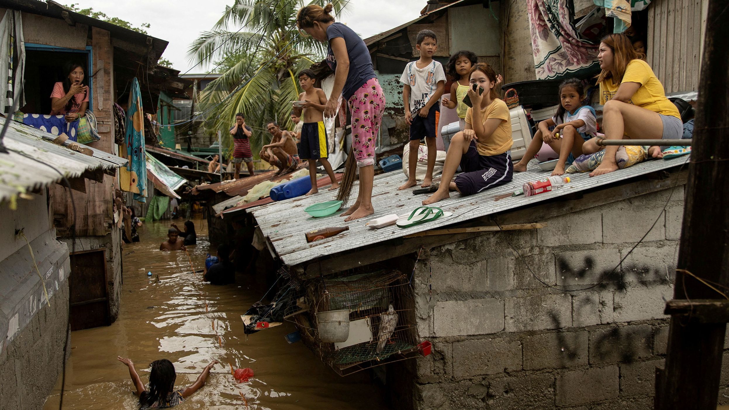 People look out from the roofs of their homes as they wait for flooding to subside in San Miguel, Philippines, on Monday, September 26. <a href="https://www.cnn.com/2022/09/26/asia/typhoon-karding-noru-philippines-deaths-intl-hnk/index.html" target="_blank">Typhoon Noru</a> made landfall the day before.