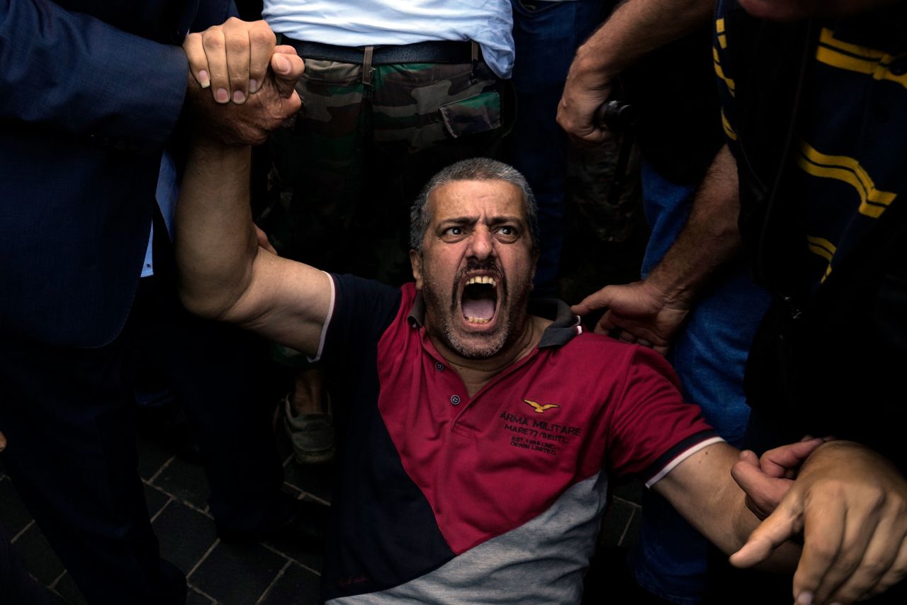 A retired army member lies on the ground and chants slogans as other protesters try to enter Lebanon's parliament building in Beirut on Monday, September 26. Protesters were demanding an increase in their monthly retirement pay, which has been affected by <a href="https://www.cnn.com/2022/09/22/asia/lebanon-banks-shut-holdups-intl/index.html" target="_blank">the country's financial crisis.</a>