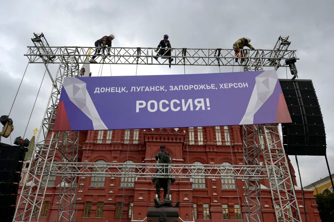 Workers fix a banner outside the Red Square in Moscow on Wednesday, ahead of a Kremlin-backed annexation plan of Ukrainian territory widely condemned by European leaders as "illegal."
