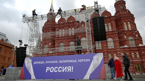 Workers fix a banner reading "Donetsk, Lugansk, Zaporizhzhia, Kherson - Russia!" on top of a construction installed in front of the State Historical Museum outside Red Square in central Moscow.