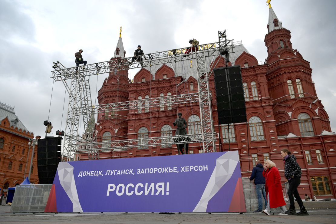 Workers fix a banner reading "Donetsk, Lugansk, Zaporizhzhia, Kherson - Russia!" on top of a construction installed in front of the State Historical Museum outside Red Square in central Moscow.