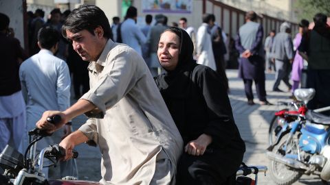 A woman arrives on a motorbike to search for a relative at a hospital in Kabul after a blast at an education center in the Afghan capital on September 30.