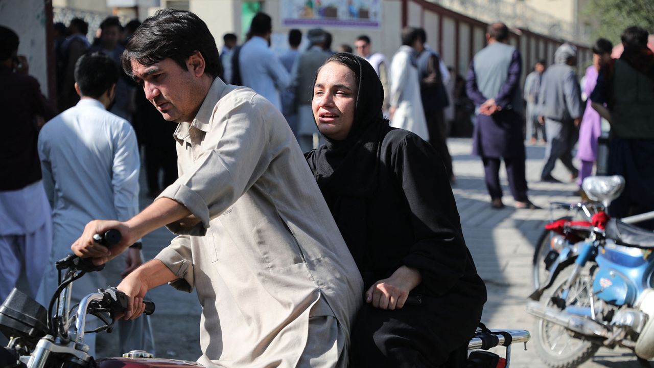A woman arrives on a motorbike to search for a relative at a hospital in Kabul  after a blast at an education center in the Afghan capital on September 30.