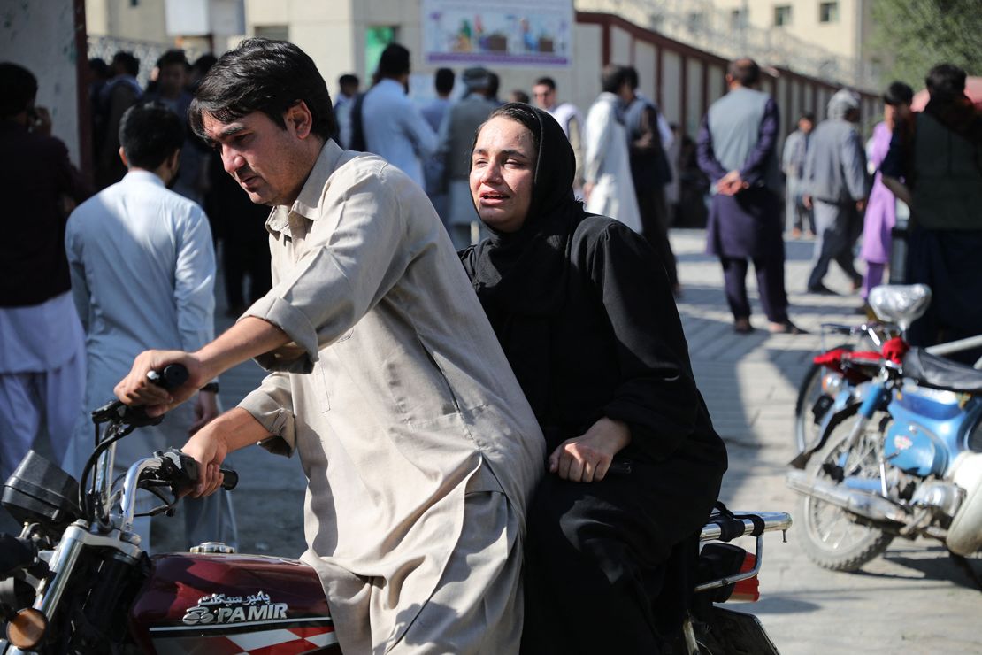 A woman arrives on a motorbike to search for a relative at a hospital in Kabul  after a blast at an education center in the Afghan capital on September 30.