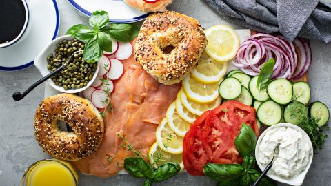 Bagels and lox platter for break fast with vegetables and cream cheese.