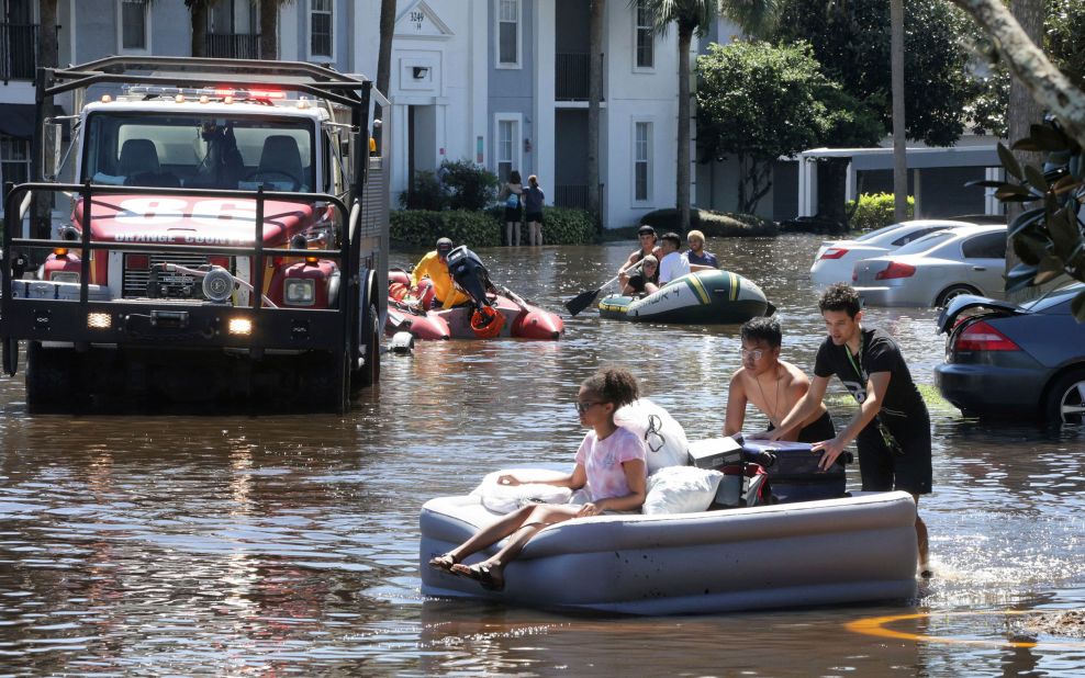 University of Central Florida students use an inflatable mattress as they evacuate an apartment complex in Orlando, Florida, on Friday, September 30. 