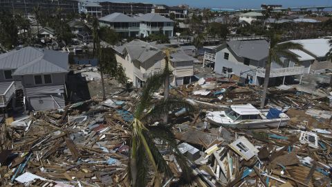 In this photo taken with a drone, debris from destroyed buildings swept from the beachfront lies amid damaged homes in Fort Myers Beach.