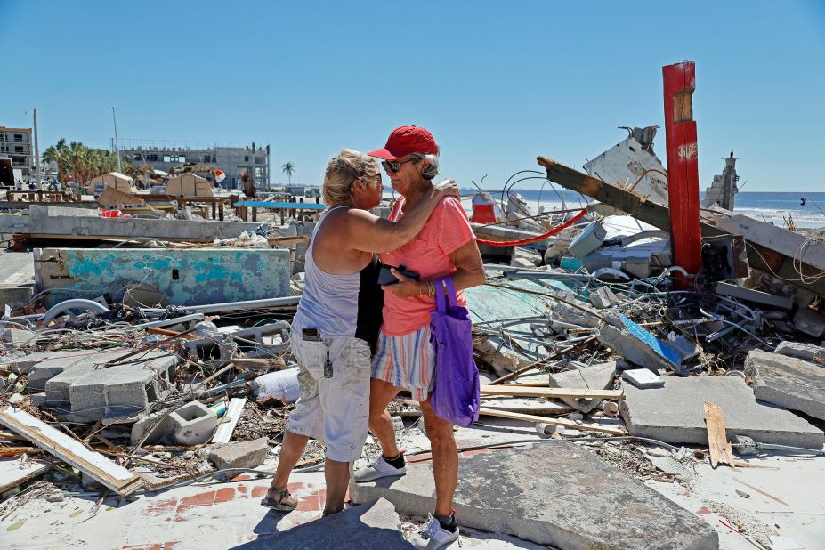 Local muralist Candy Miller, left, embraces Ana Kapel, the manager of the Pier Peddler, a gift shop that sold women's fashions, as she becomes emotional at the site where the store once stood on Fort Myers Beach on Friday.