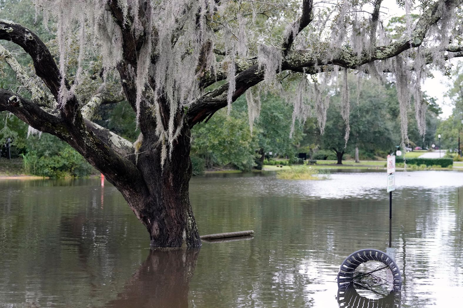 Waters from a rain-swollen pond cover grass and a foot path around Quarterman Park in North Charleston, South Carolina, on Friday.