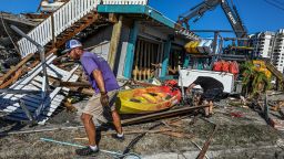 Workers and residents clear debris from a destroyed bar on San Carlos Island in Fort Myers after Hurricane Ian hit Florida, on October 1, 2022. Shocked Florida communities counted their dead Saturday as the full scale of the devastation came into focus, two days after Hurricane Ian tore into the coastline as one of the most powerful storms ever to hit the United States. 