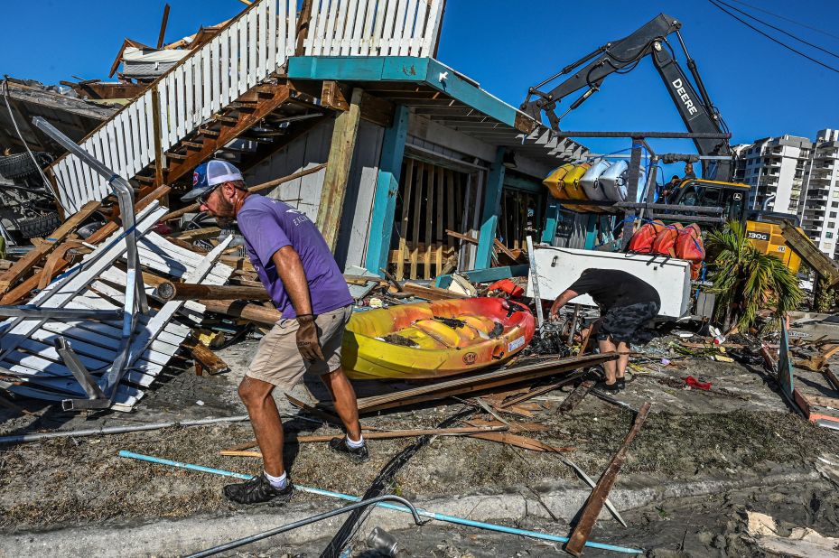 Workers and residents clear debris from a destroyed bar in Fort Myers on Saturday, October 1.