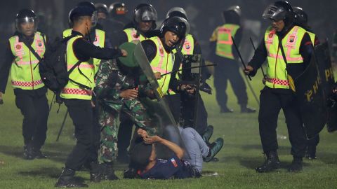 インドネシア東部ジャワ・マランのカンジュールなスタジアムで、2人のインドネシアサッカーチームの支持者が衝突している間、セキュリティエージェントはファンを拘禁している。