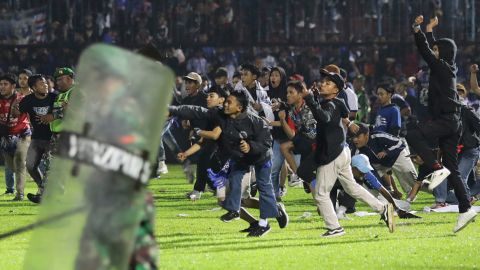サッカーファンが土曜日、東部ジャワ・マランのカンジュールなスタジアムで競技場を侵犯している。