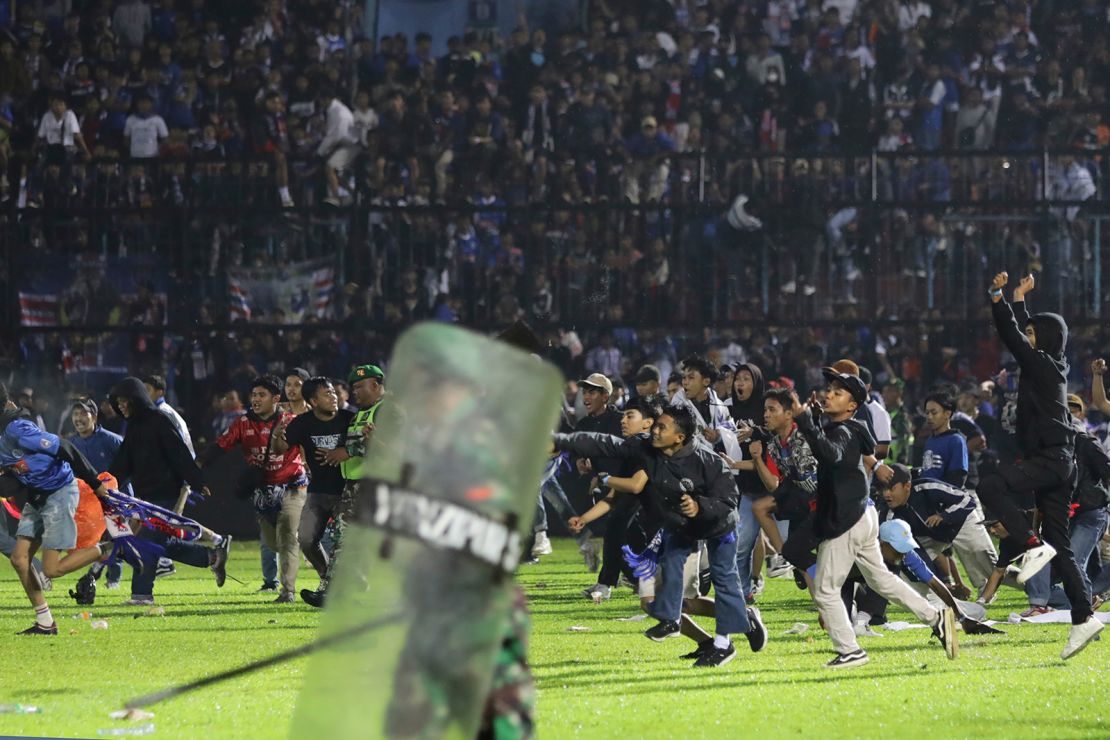 Soccer fans invade the pitch at the Kanjuruhan Stadium in Malang, East Java on Saturday.