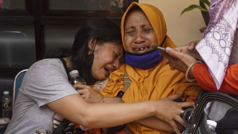 女性たちは殺された人々の中に家族がいるという確認を受けて涙を流す。