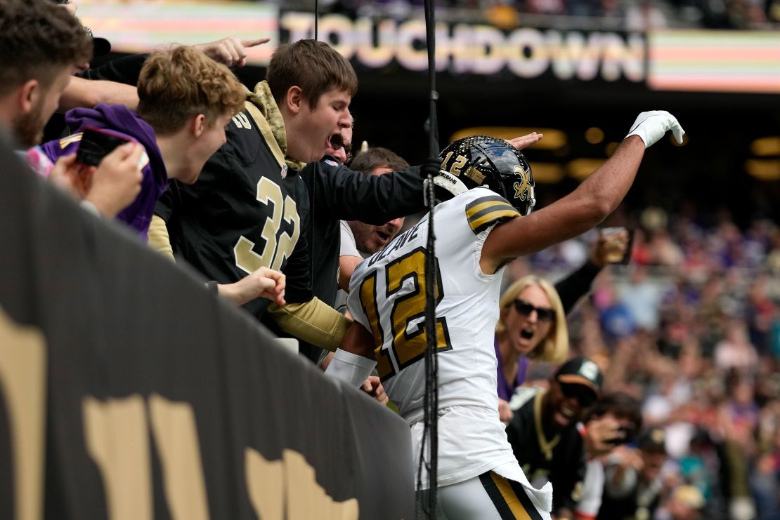 Chris Olave jumps into the crowd after scoring a touchdown against the Vikings. 