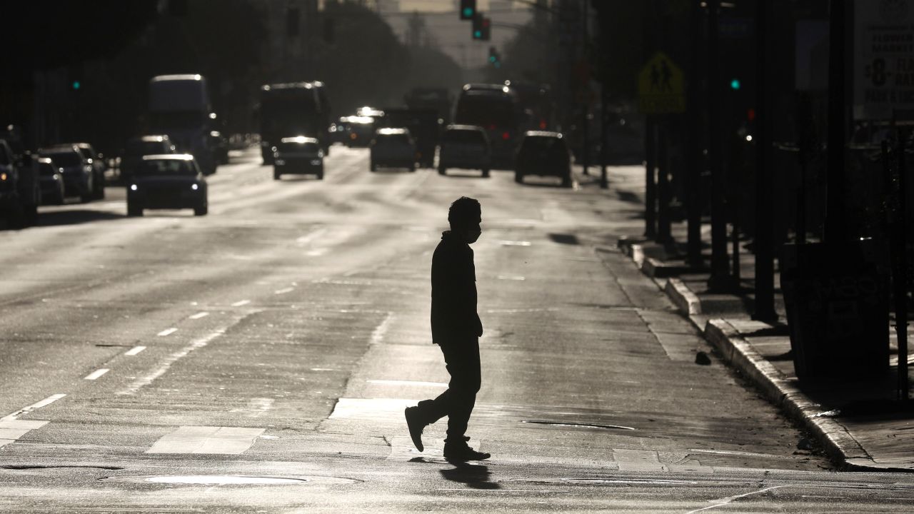 A pedestrian crosses a street in downtown Los Angeles on Dec. 3, 2020.